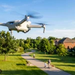 Drone quadricoptère blanc volant au-dessus d'un quartier