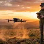 Femme pilotant un drone dans un paysage désertique doré