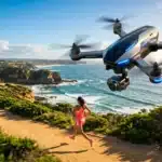 Drone FPV survolant une joggeuse sur une plage côtière