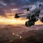 Drone quadricoptère noir survolant vallée montagne coucher soleil